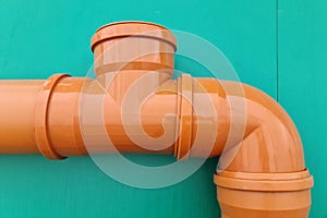 Connection from a tee and a 90 degree bend on an orange sewer pipe, 100mm photo
