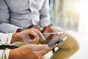 Connectivity is everything in the modern business world. Closeup shot of two businesspeople using digital devices in