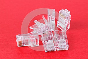 Connectors for networking ethernet cable with RJ45 on red background. Close-up