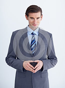 Conniving businessman. A conniving young businessman with his fingers together while isolated on white. photo