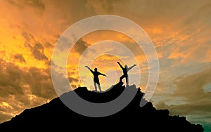 The conquest of the summit, the silhouettes of two people on top of the mountai