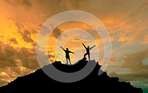 The conquest of the summit, the silhouettes of two people on top of the mountai photo