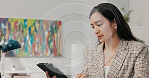 A conscientious organized office worker in a large corporation sits at desk synchronizing documents on tablet with