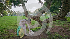 Conscious girl picking trash demonstrating environmental responsibility.