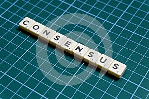 Consensus word made of square letter block on green square mat background