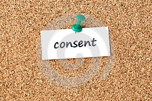 Consent. Word written on a piece of paper, cork board background