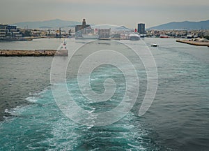 Conseptual shot of the ship that is leaving the port the other ships and the command tower ,in a cloudy day with calm sea