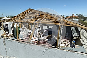 Consequences of natural disaster. Damaged house roof with missing shingles and broken apart walls after hurricane Ian in