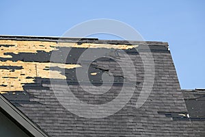 Consequences of natural disaster. Damaged house roof with missing shingles after hurricane Ian in Florida