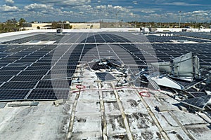 Consequences of natural disaster. Damaged by hurricane wind photovoltaic solar panels mounted on industrial building