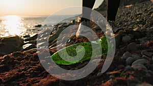 Conservation of ecology and Earth Day. A volunteer walking down the beach and pick up plastic bottle. Coastal cleanup