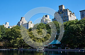 Conservatory Water is model boat pond in Central Park, NYC. Beyond the trees are apartment buildings on Fifth Avenue