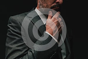 Consideration before starting a business, elegant businessman in gray suit thinking and planning photo