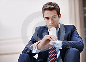 Considering his options. A handsome businessman looking thoughtful while sitting with the stock pages.