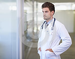 Considering his patients treatment options. a handsome young doctor.