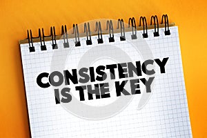 Consistency Is The Key text quote on notepad, concept background