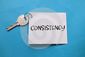 Consistency is the key, text words typography written on paper against blue background, life and business motivational