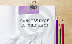 CONSISTENCY IS THE KEY text written on a paper with pencils on the desk in the office