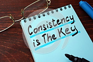 Consistency is The Key written on a notepad.