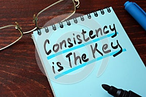 Consistency is The Key written on a notepad. photo