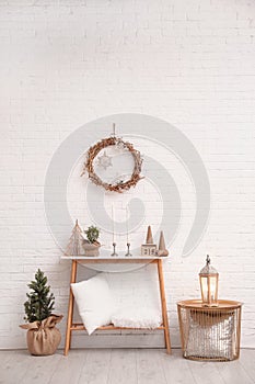 Console table with Christmas decoration near wall. Idea for festive interior