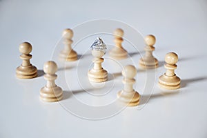 Conspiracy theory and manipulation concept in coronavirus time, group of pawn chess pieces are surrounding a piece with a tinfoil