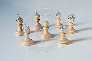 Conspiracy theory and manipulation concept in coronavirus time, group of pawn chess pieces with tinfoil helmets on their heads are