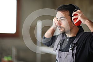 Consruction worker putting noise cancellation headphone photo