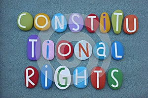 Constitutional Rights, creative slogan composed with multi colored stone letters over green sand