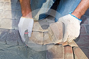 Construc worker fixing the pavestone on the roadtion worker installing stone blocks on pavement