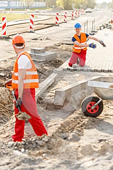 Construcion workers laying brick pavement