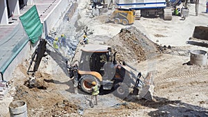 Construciton workers on a site wth excavator