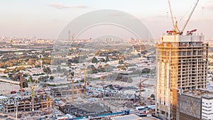 Construction activity in Dubai downtown with cranes and workers timelapse, UAE.