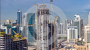 Construction activity in Dubai downtown with cranes and workers timelapse, UAE.