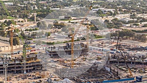 Construction activity in Dubai downtown with cranes and workers timelapse, UAE.