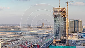 Construction activity in Dubai downtown with cranes and workers timelapse, UAE.