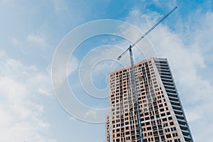 Construction activity of modern building in the city with turret slewing crane in daytime