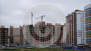 Construction apartment house progress timelapse. Construction site in Russia with cranes on the roof and clouds on a blue sky