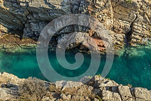 Construction with arch rocky coast & translucent sea