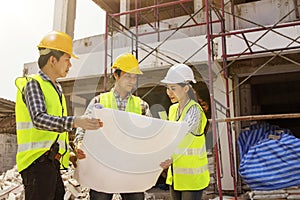 The construction architect team stood for a meeting to plan in front of the construction site.