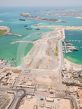 Construction of an artificial island Palm Jumeirah with construction equipment in Dubai.