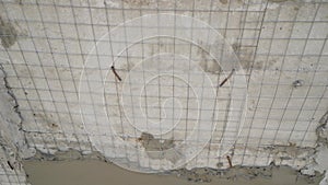 Construction background prepared surface of the facade wall of the building with a fixed mesh for cementing and painting