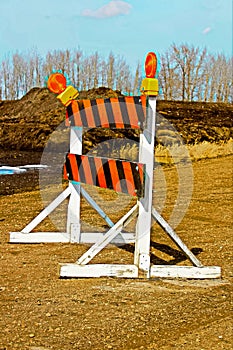 A construction barricade on a gravel road