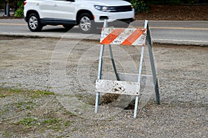 Construction barricade with a white car on the background