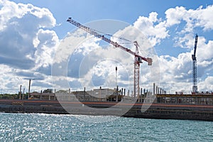 Construction on beach. Cranes against the sky