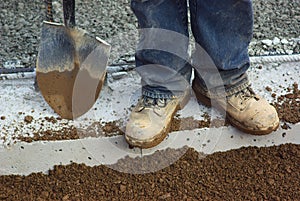 Construction boots shovel digging man working close-up on work clothes
