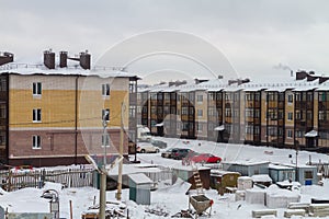 Construction of brick low-rise buildings in a new neighborhood. Residential complex in an eco-friendly area in winter