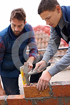 Construction, bricklayer and men with tools for building a brick wall, handyman or contractor with trade, mentor and