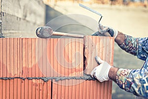 Construction bricklayer worker building walls with bricks and mortar