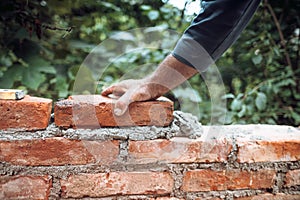 Industry details - Construction bricklayer worker building walls with bricks, mortar and putty knife